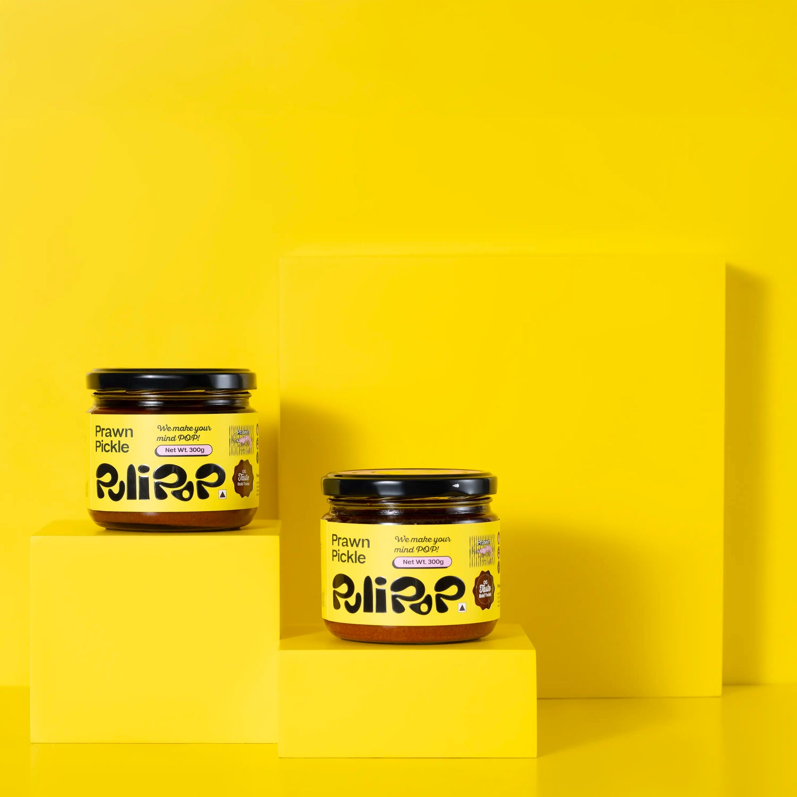Two jars of Prawn Pickle by PuliPOP on yellow pedestals