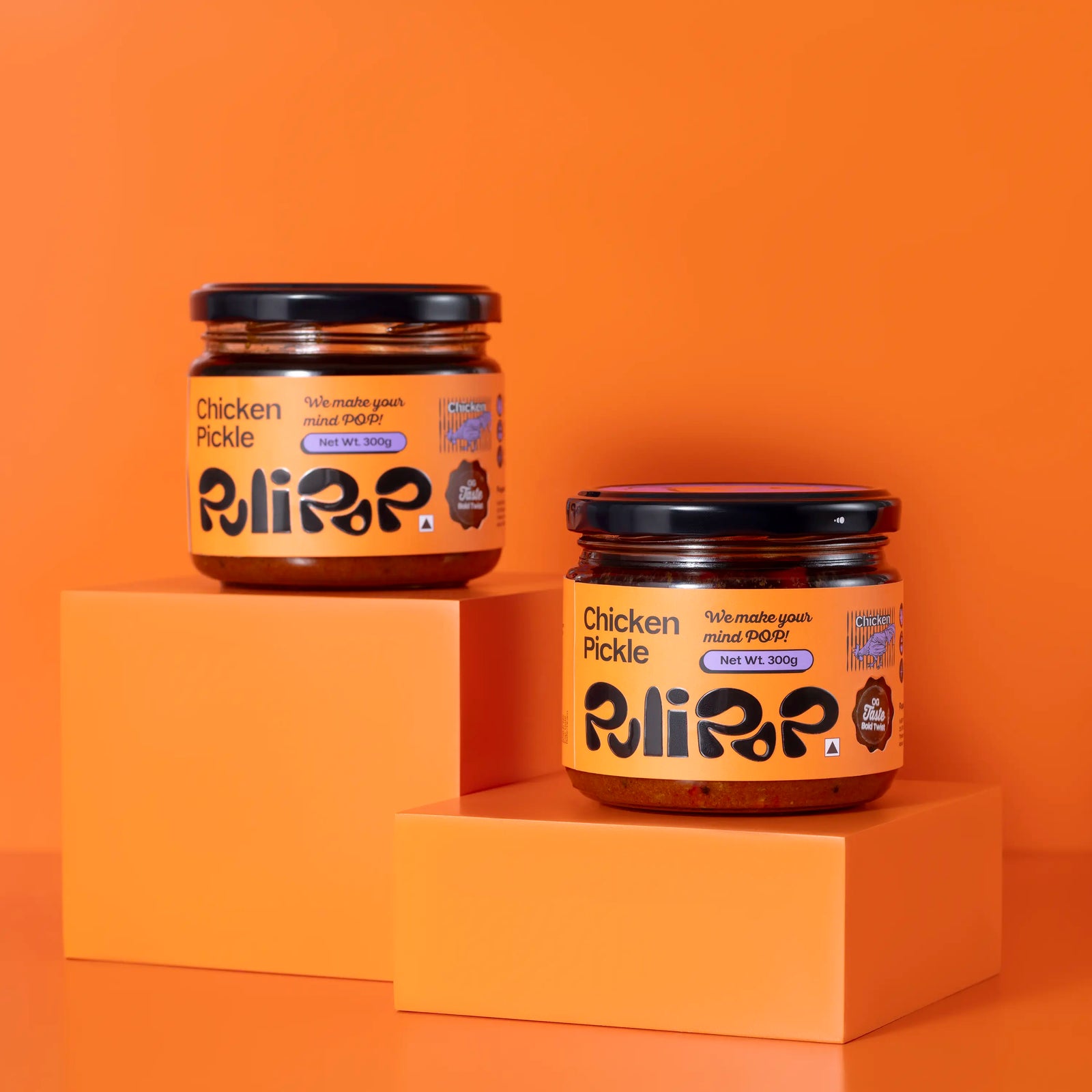 Two jars of Chicken Pickle by PuliPOP on orange pedestals