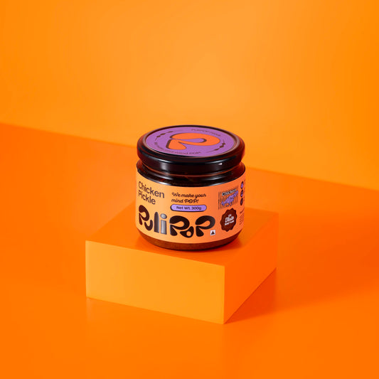 Chicken Pickle by PuliPOP 300g glass jar with orange label on orange pedestal