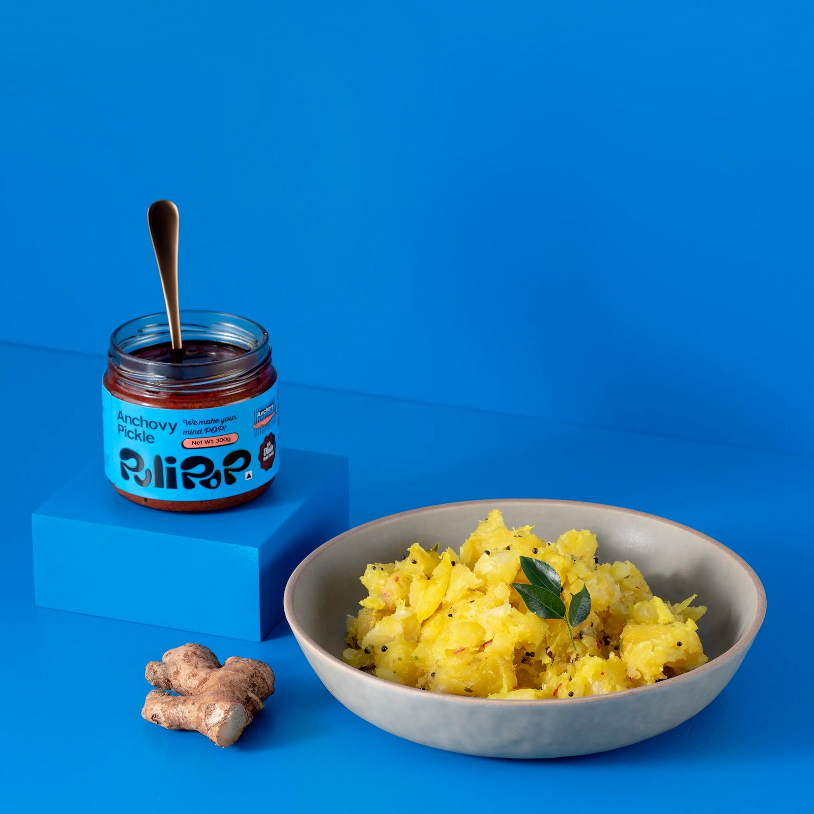 Anchovy Pickle by PuliPOP with a bowl of upma, fresh ginger root and curry leaves