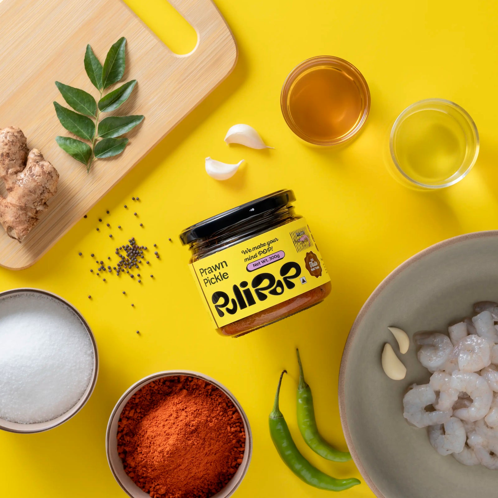 Prawn Pickle by PuliPOP surrounded by raw prawns, green chillies, gingelly oil and spices
