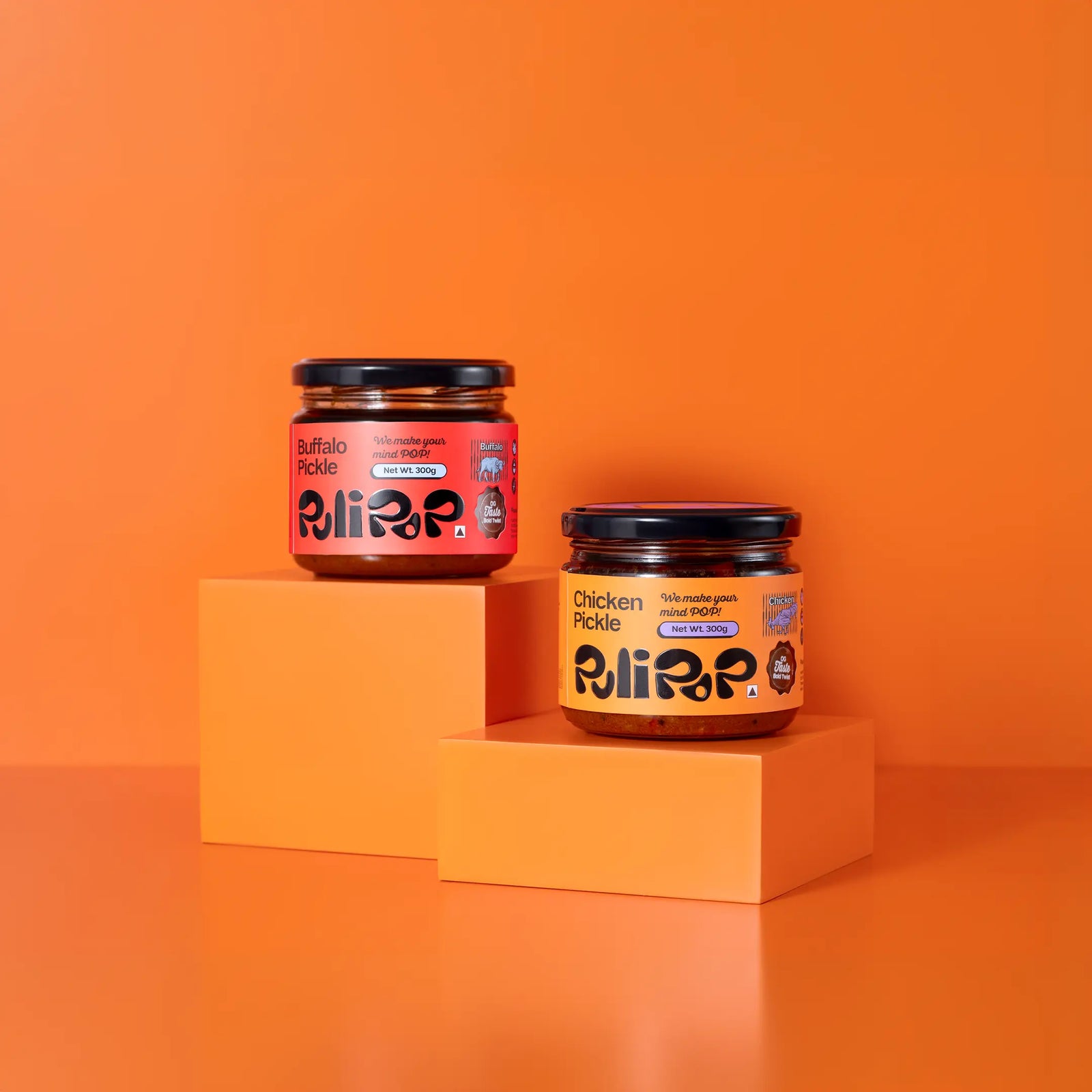 The Land POP bundle by PuliPOP showing Buffalo Beef Pickle and Chicken Pickle jars on orange pedestals